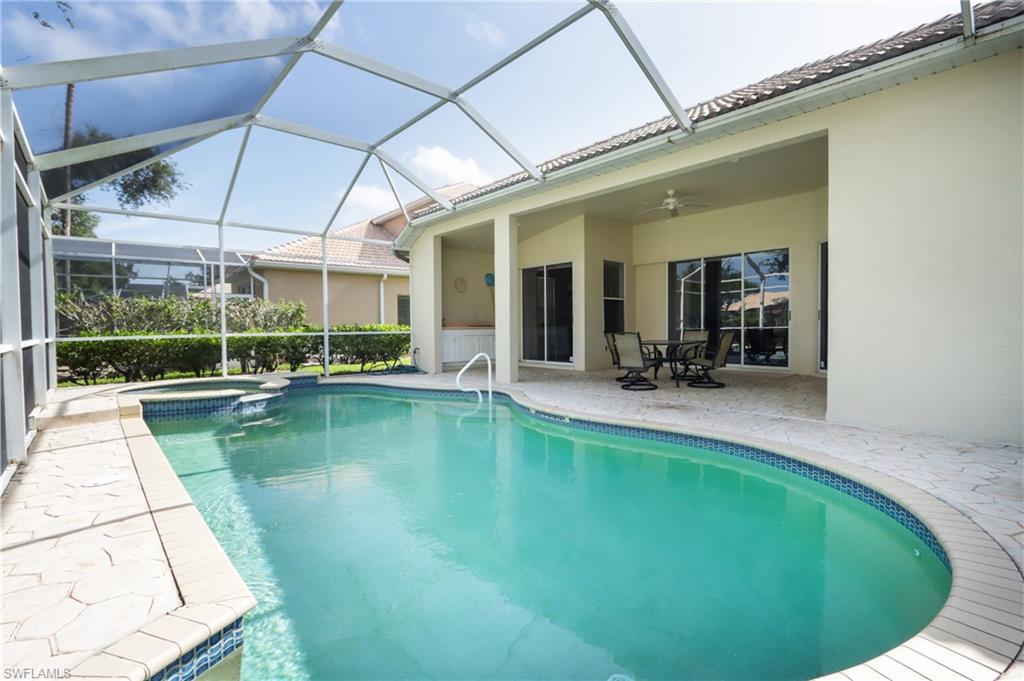 View of swimming pool with a patio area, a ceiling fan, a pool with connected hot tub, and a lanai