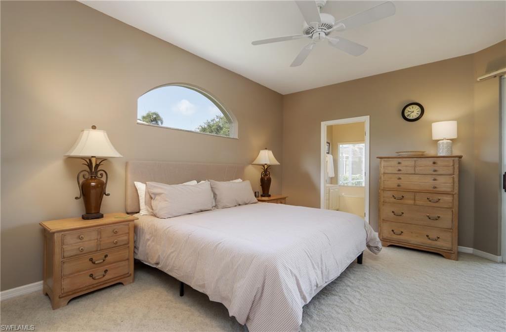 Bedroom with light carpet, a ceiling fan, and ensuite bathroom