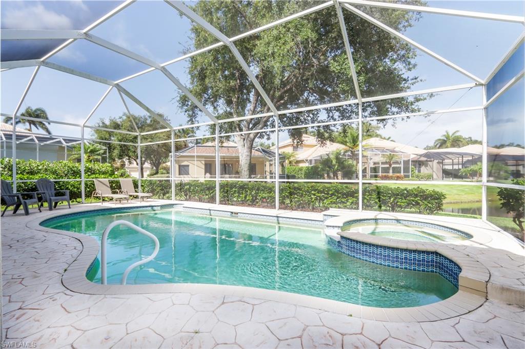 View of pool featuring a patio area, a pool with connected hot tub, and glass enclosure