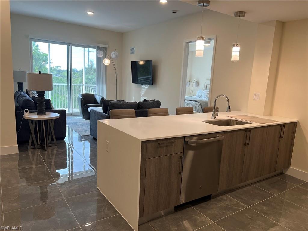 Kitchen featuring pendant lighting, stainless steel dishwasher, and sink
