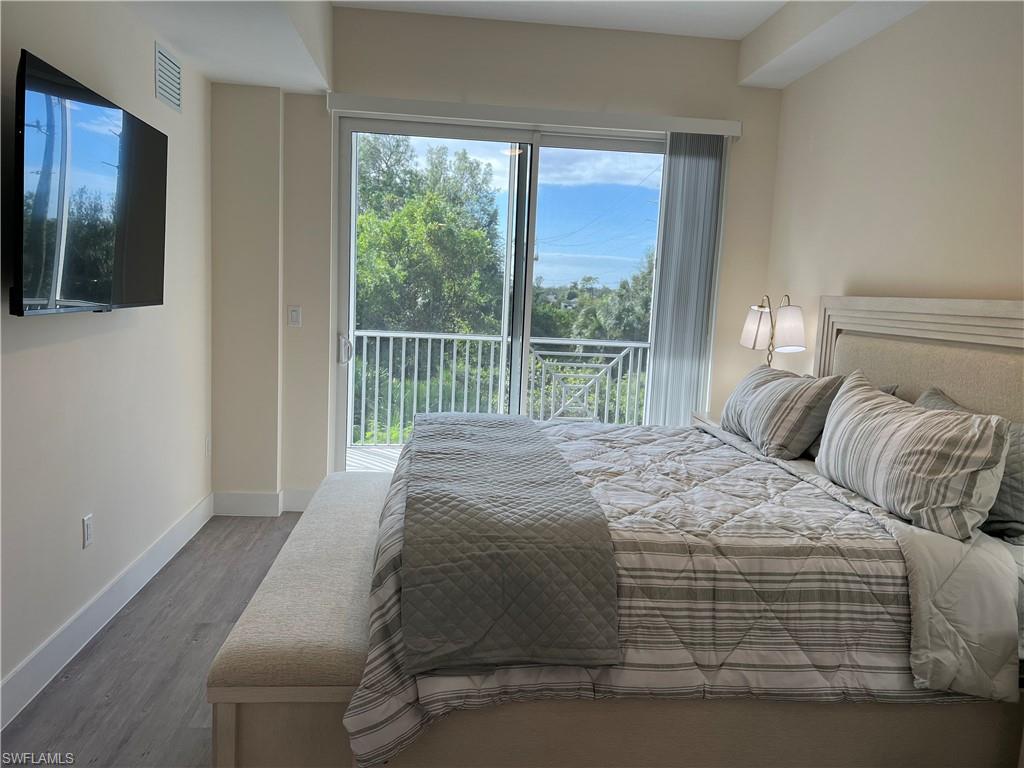 Bedroom with hardwood / wood-style floors and access to outside