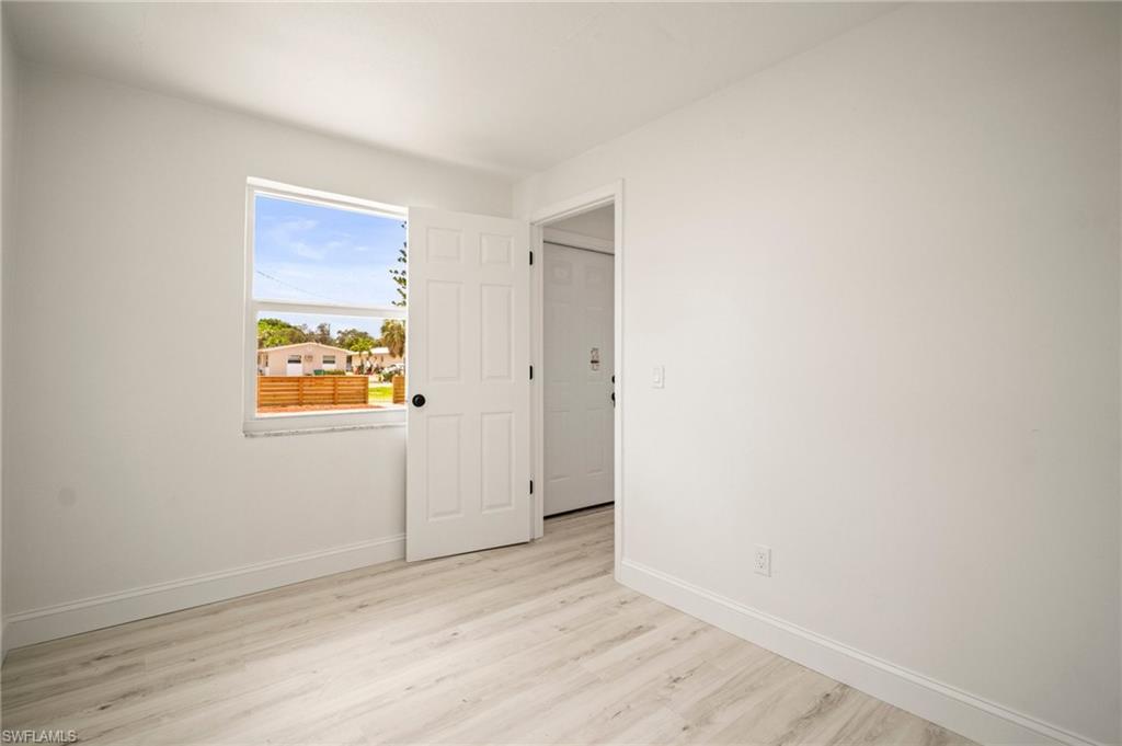 Unfurnished room featuring baseboards and light wood finished floors