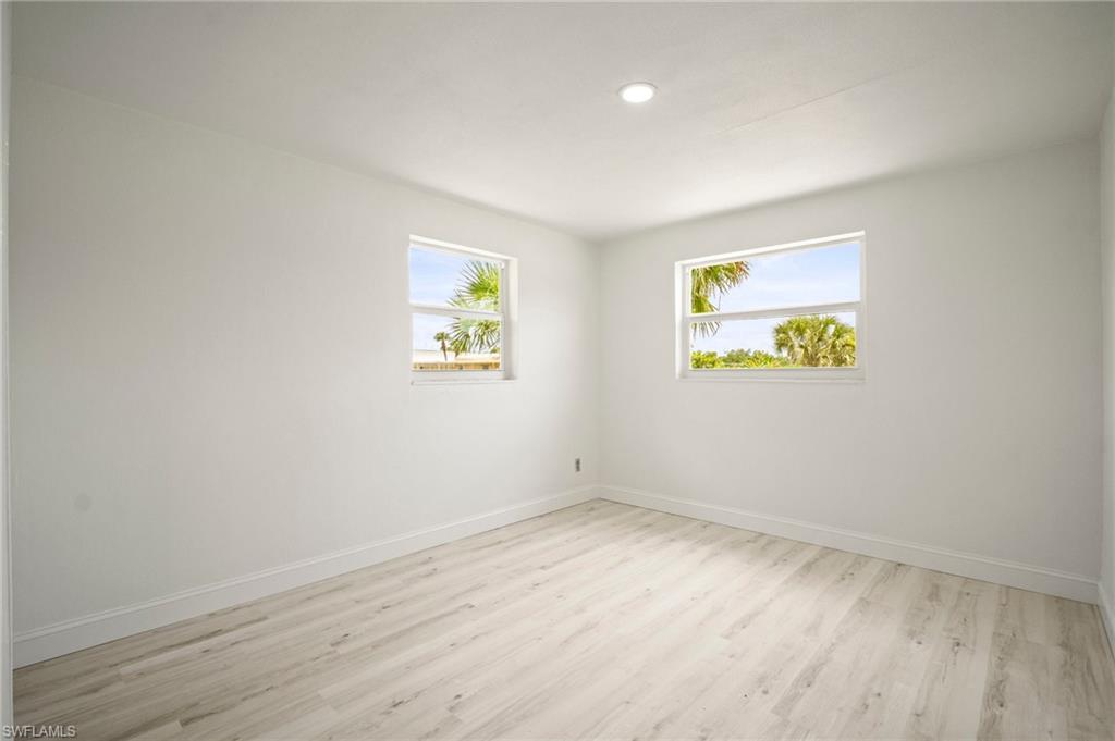 Empty room with light wood-style floors and recessed lighting