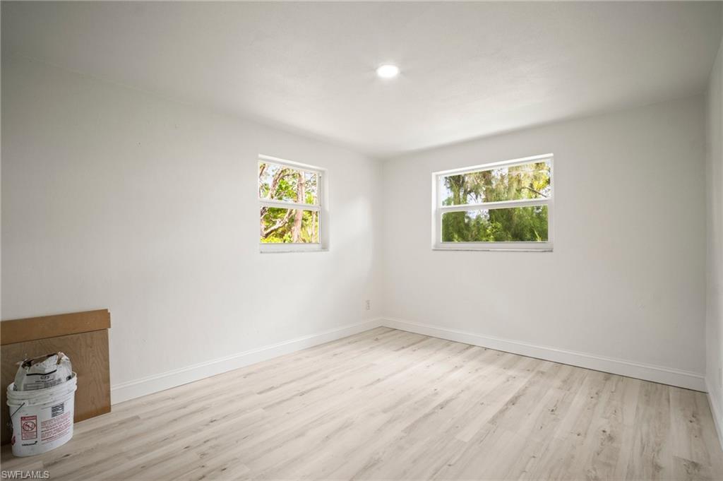 Empty room with light wood-style floors and recessed lighting