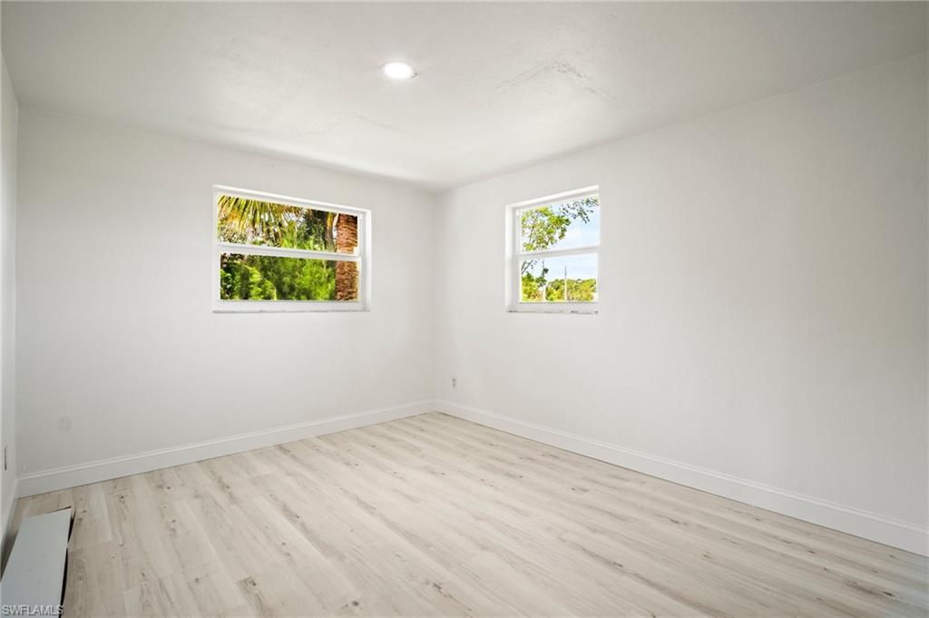 Empty room with light wood-style flooring and recessed lighting
