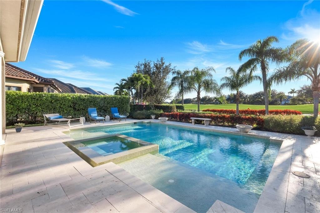 View of pool with a patio area and a pool with connected hot tub