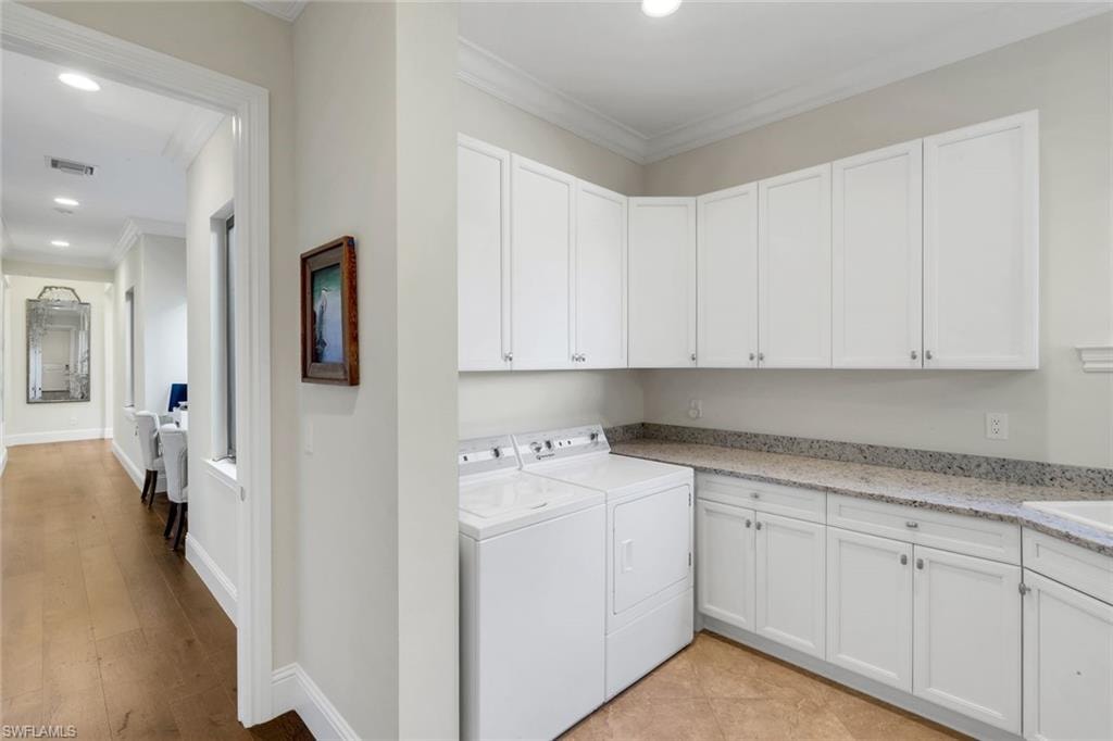 Washroom featuring crown molding, washing machine and clothes dryer, cabinet space, and recessed lighting