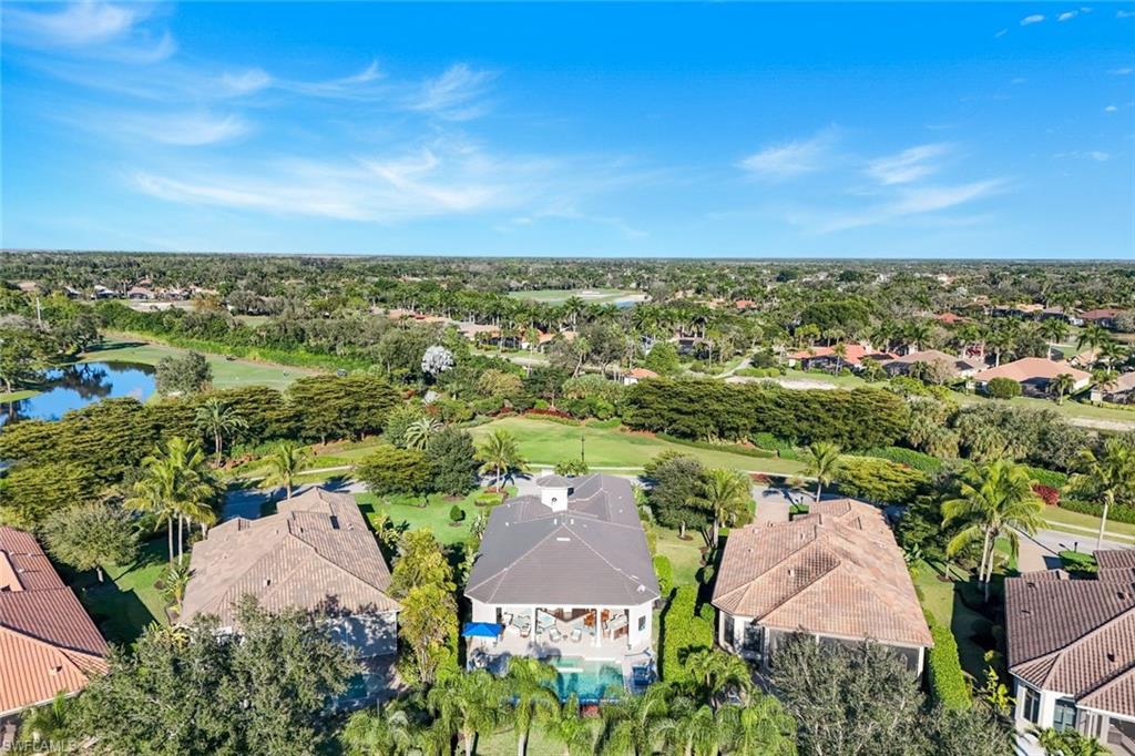 Aerial overview of property's location with nearby suburban area, a golf course, and a nearby body of water