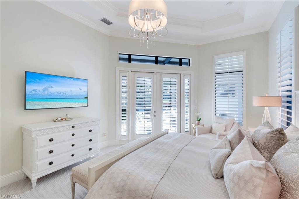 Bedroom with access to exterior, plantation shutter, french doors, crown molding, carpet, and a tray ceiling