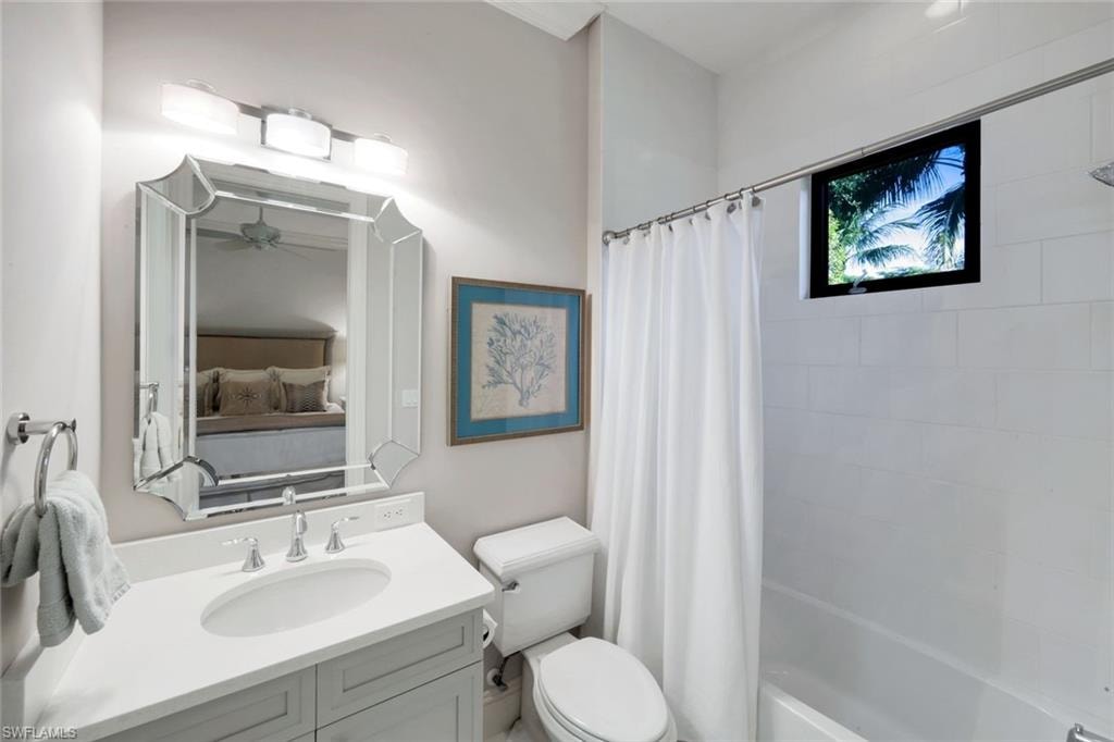 Full bath with tub shower / bath combination with curtain, vanity, and connected WIC
