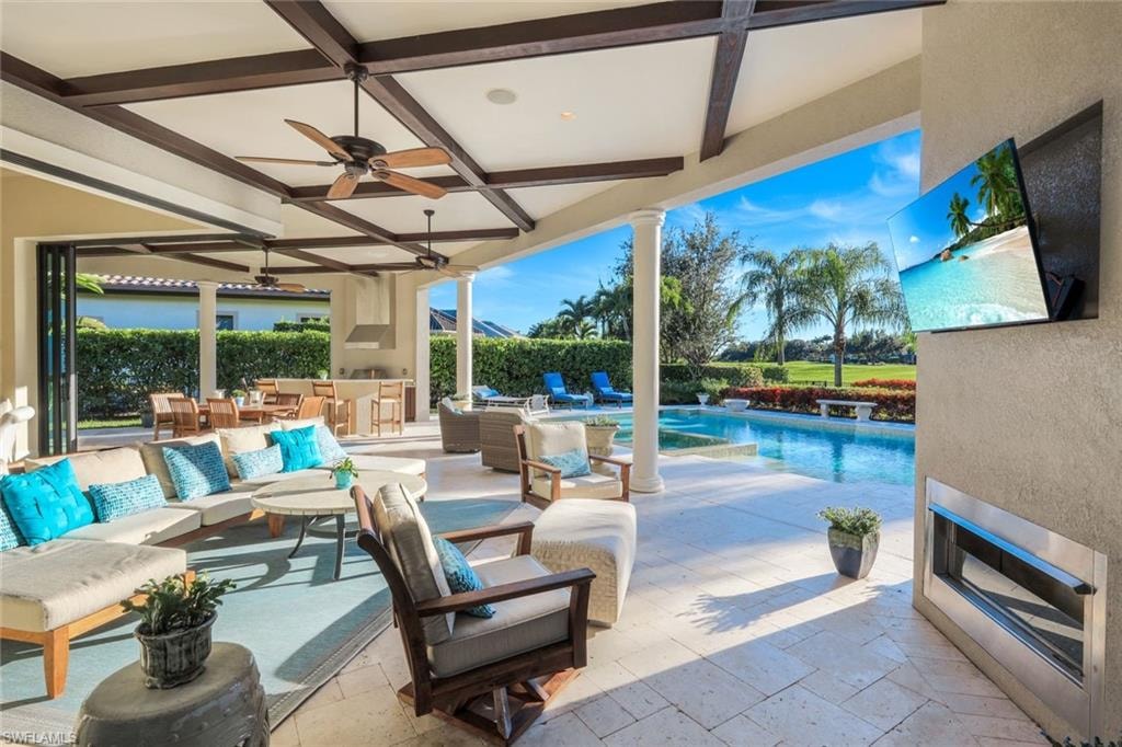 Outside lanai, TV, Fireplace with ceiling fan and an outdoor hangout area