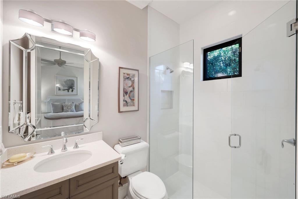 Ensuite bathroom featuring a stall shower and vanity and WIC