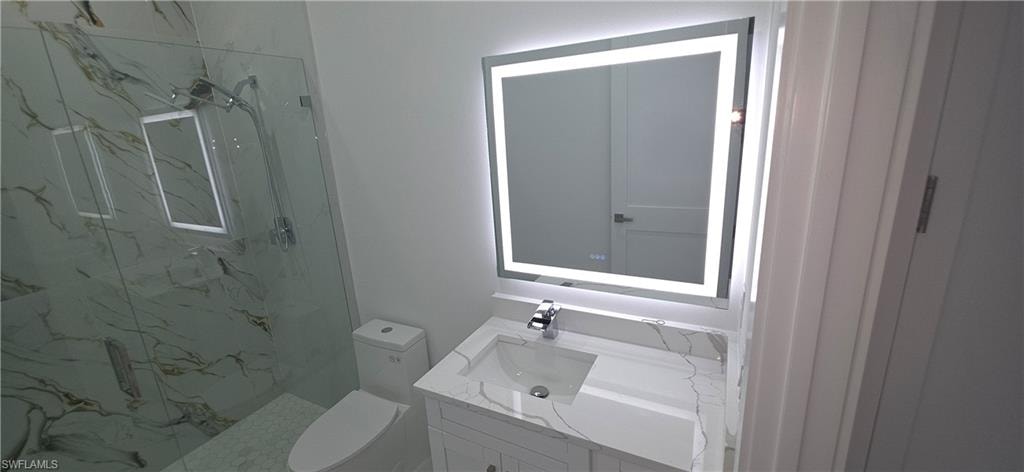 Bathroom featuring a modern vanity with integrated sink, chrome faucet, and stone countertop