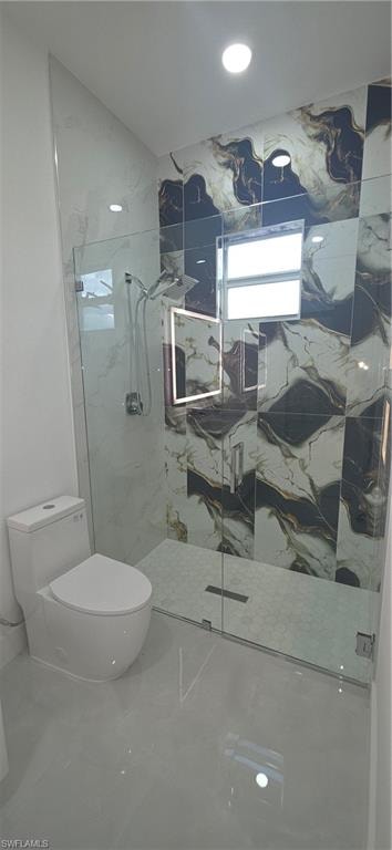 Bathroom featuring a glass-enclosed shower with contrasting wall tiling, a linear drain, and a rain shower head