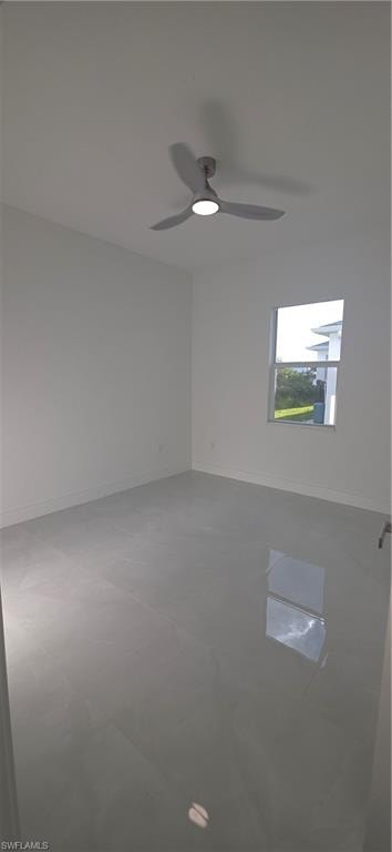 Spacious room featuring light-toned flooring, white walls, and a modern ceiling fan with integrated lighting