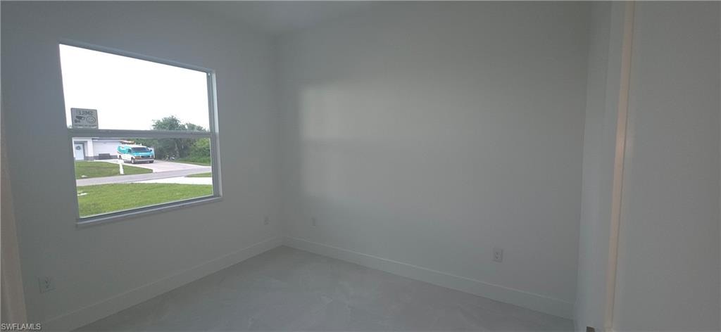Interior room featuring light-toned walls, a single-pane window, and light-toned flooring