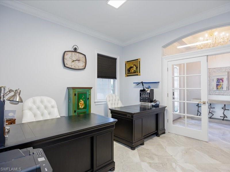Room featuring light-toned walls, crown molding, and large format tile flooring