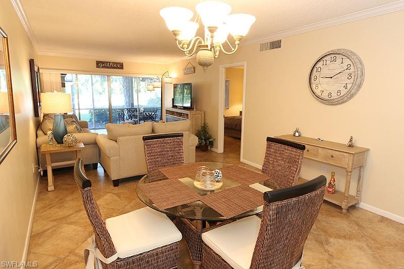 Tiled dining area featuring a chandelier and ornamental molding