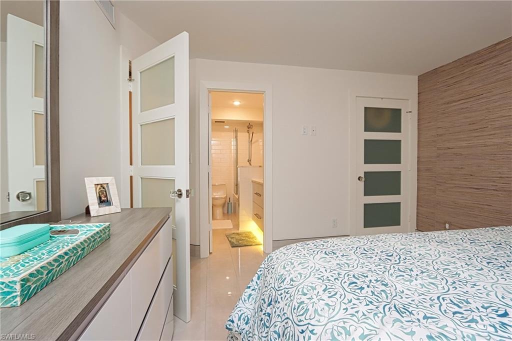 Tiled bedroom featuring ensuite bathroom