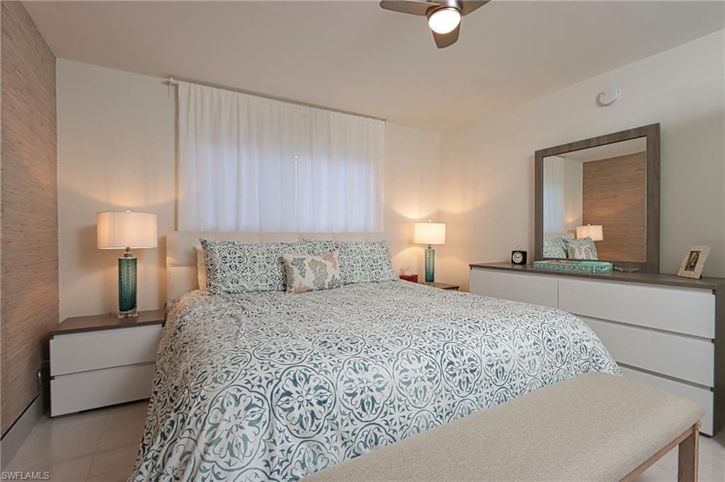 Bedroom with ceiling fan and light tile flooring