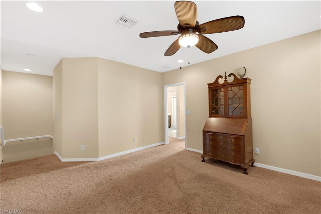 Empty room with light colored carpet and ceiling fan