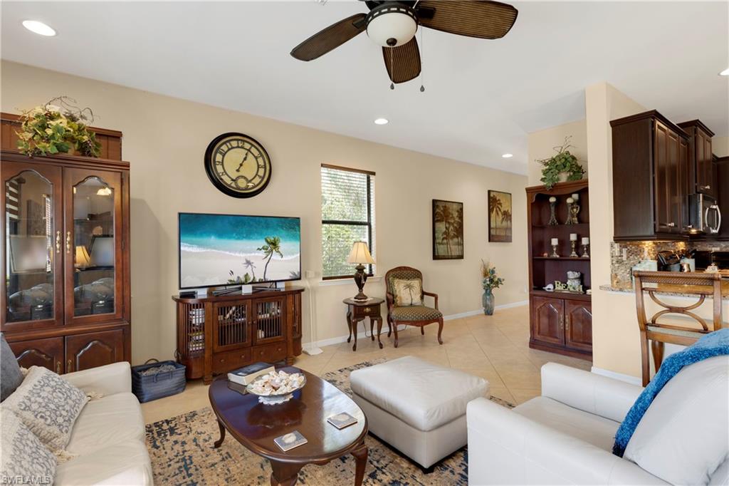 Living room with ceiling fan and light tile patterned flooring
