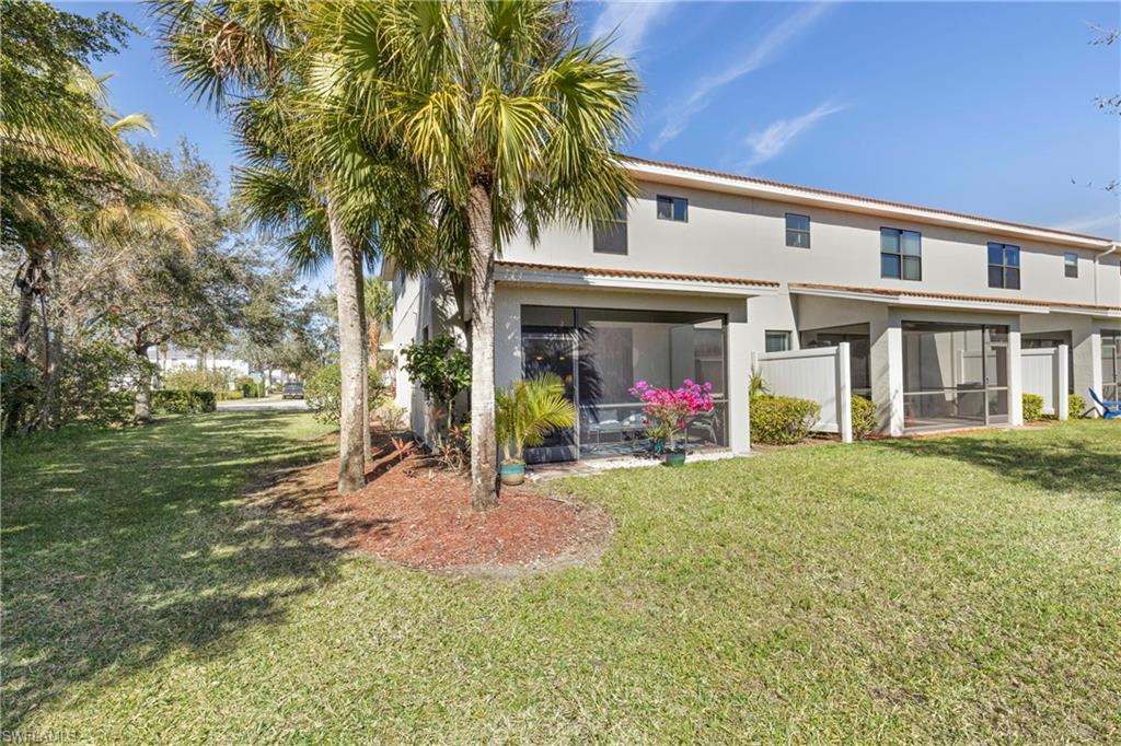 Rear view of property featuring a sunroom and a lawn