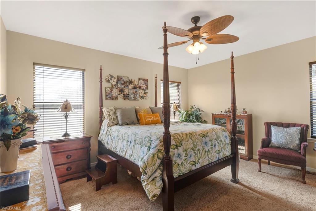 Carpeted bedroom featuring ceiling fan