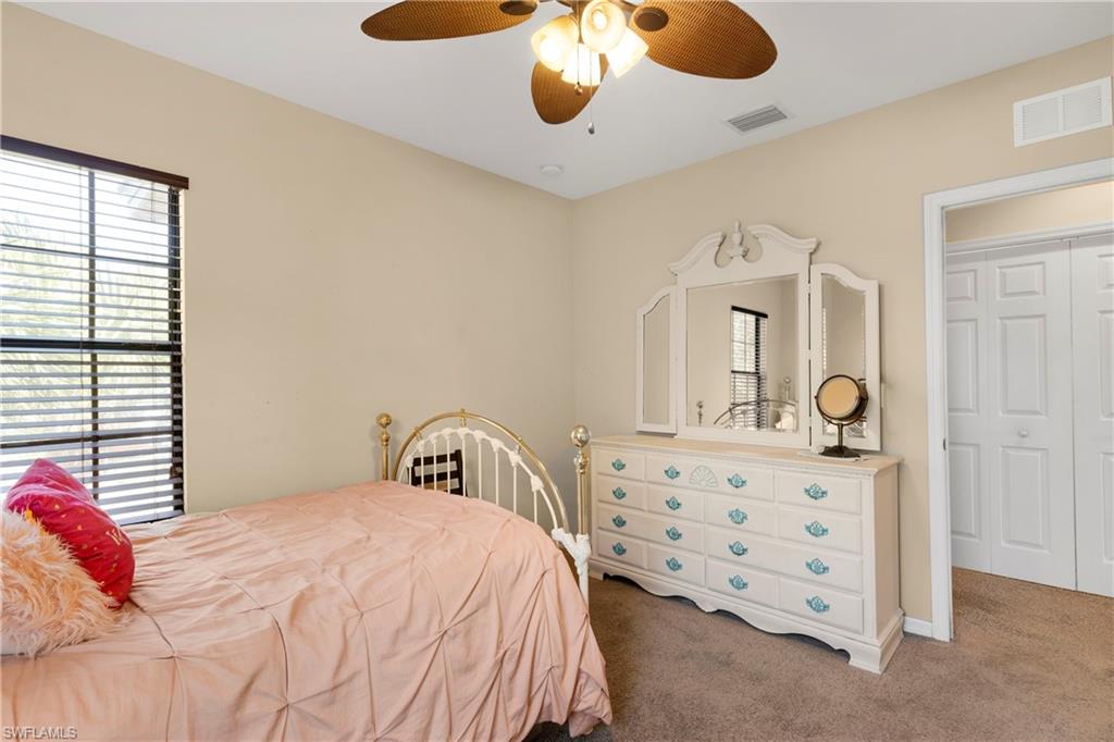 Bedroom with multiple windows, carpet floors, and ceiling fan
