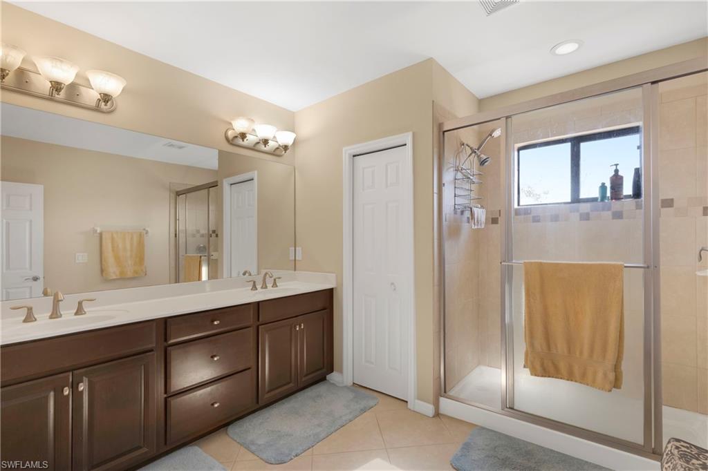 Bathroom with tile patterned flooring, vanity, and walk in shower