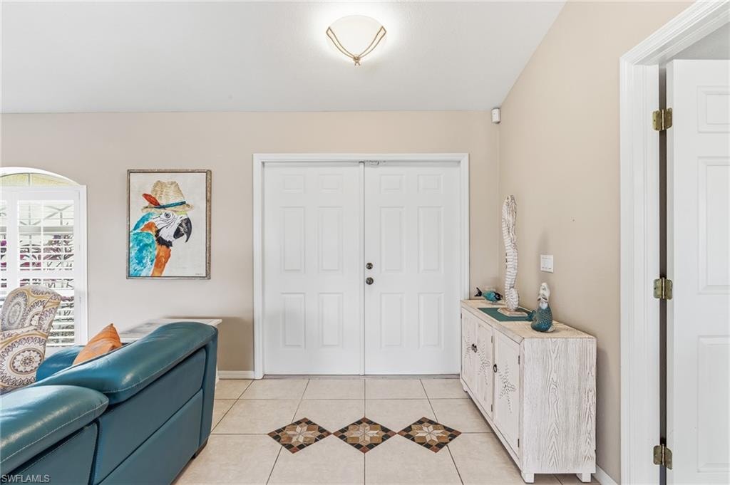Property features neutral-toned walls, tile flooring with decorative accents, and a double entry door.