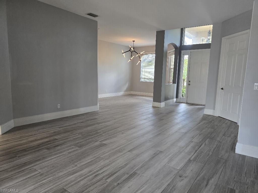 Spacious main living area featuring wood-finish flooring, neutral gray wall tones, and white baseboards