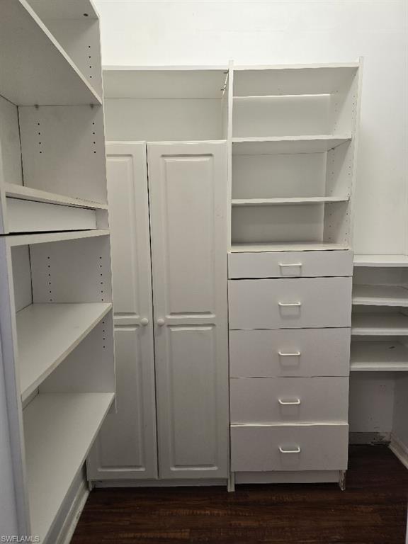 Custom closet system featuring white built-in shelving, drawers, and cabinetry