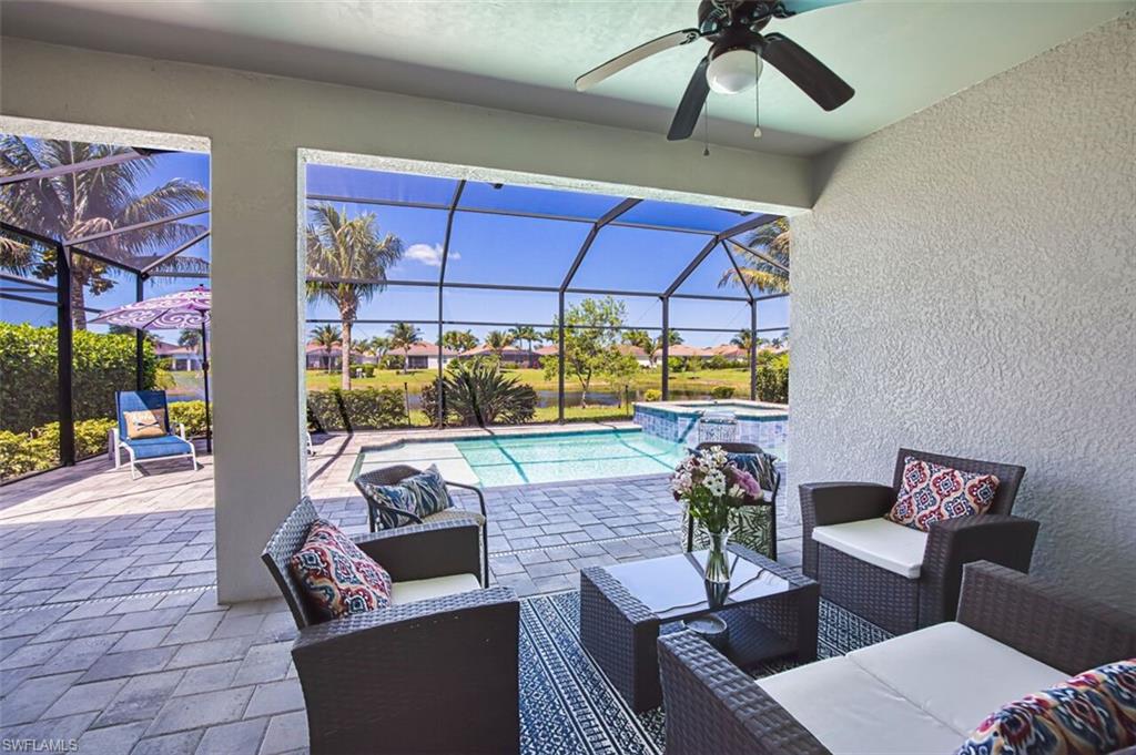 Screened patio featuring a ceiling fan, textured wall finish, and paver flooring