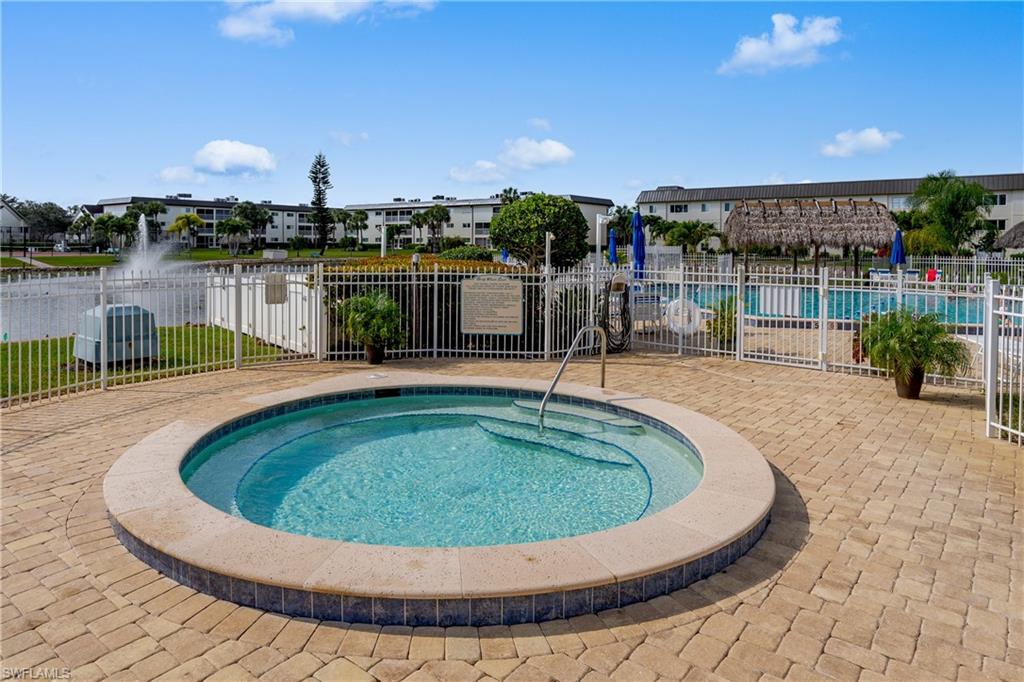 Circular hot tub featuring integrated steps and a surrounding paver patio
