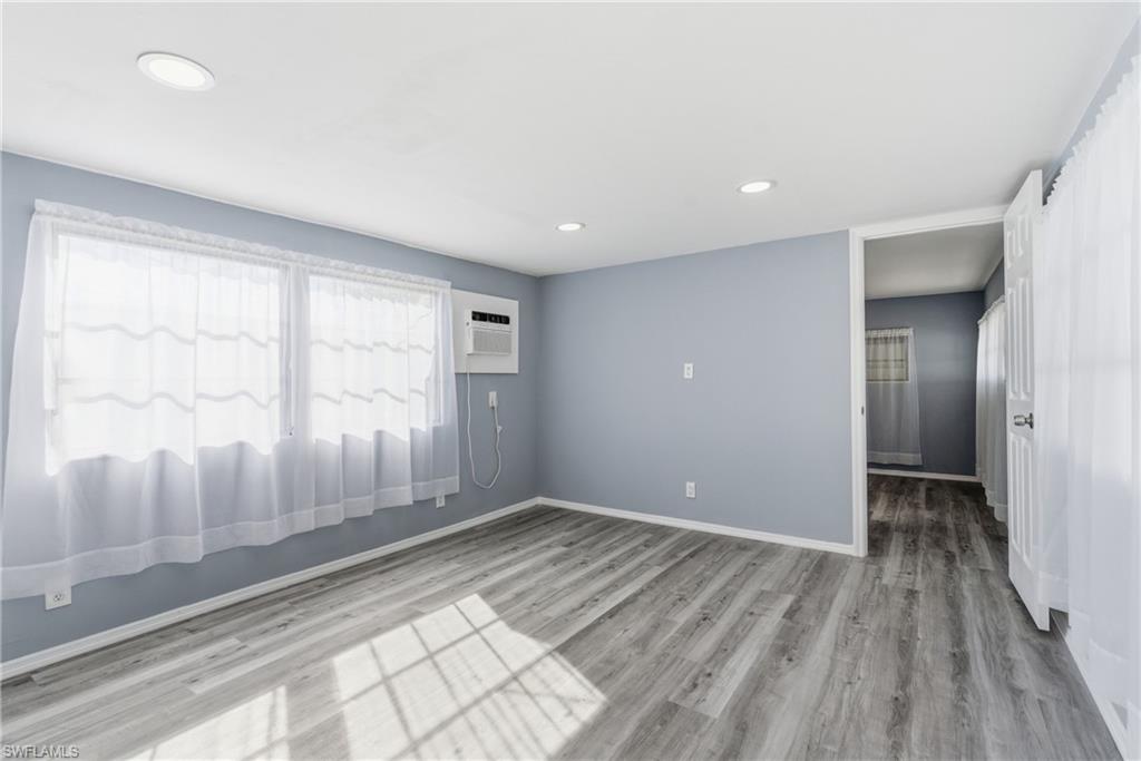 Spare room featuring light wood-style flooring, recessed lighting, and a wall mounted air conditioner