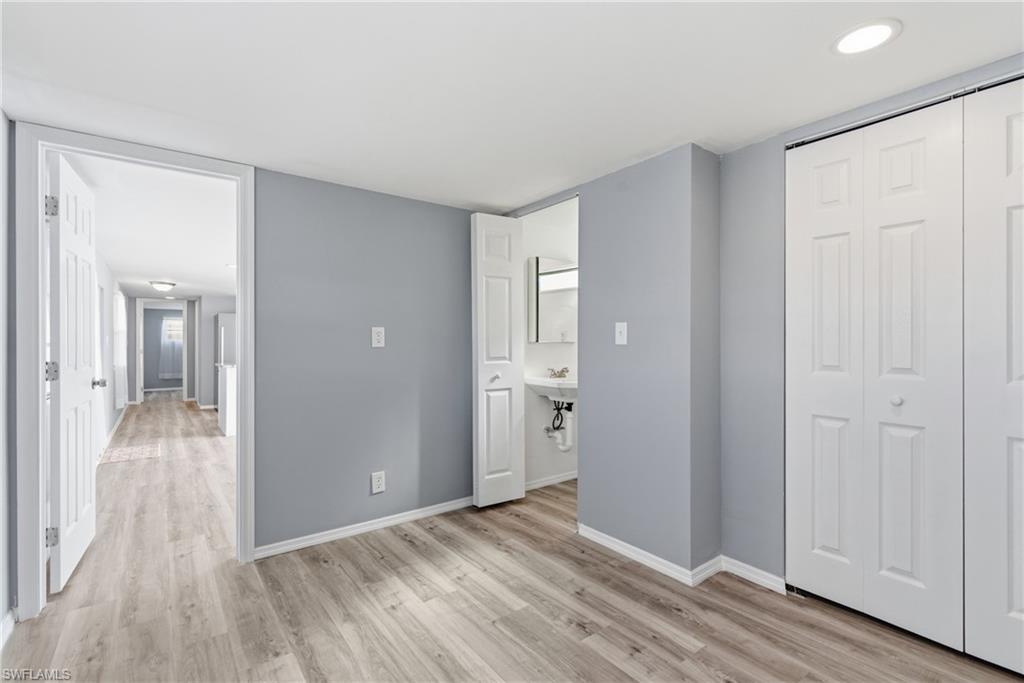 Primary bedroom with half bathroom and a closet