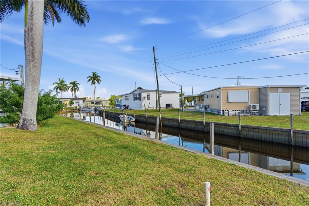 View of green lawn featuring a water view and a residential view