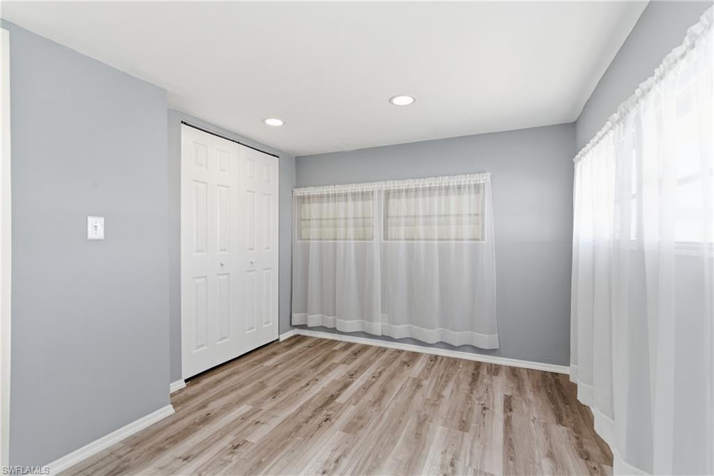 Primary bedroom with a closet, light wood-style flooring, and recessed lighting