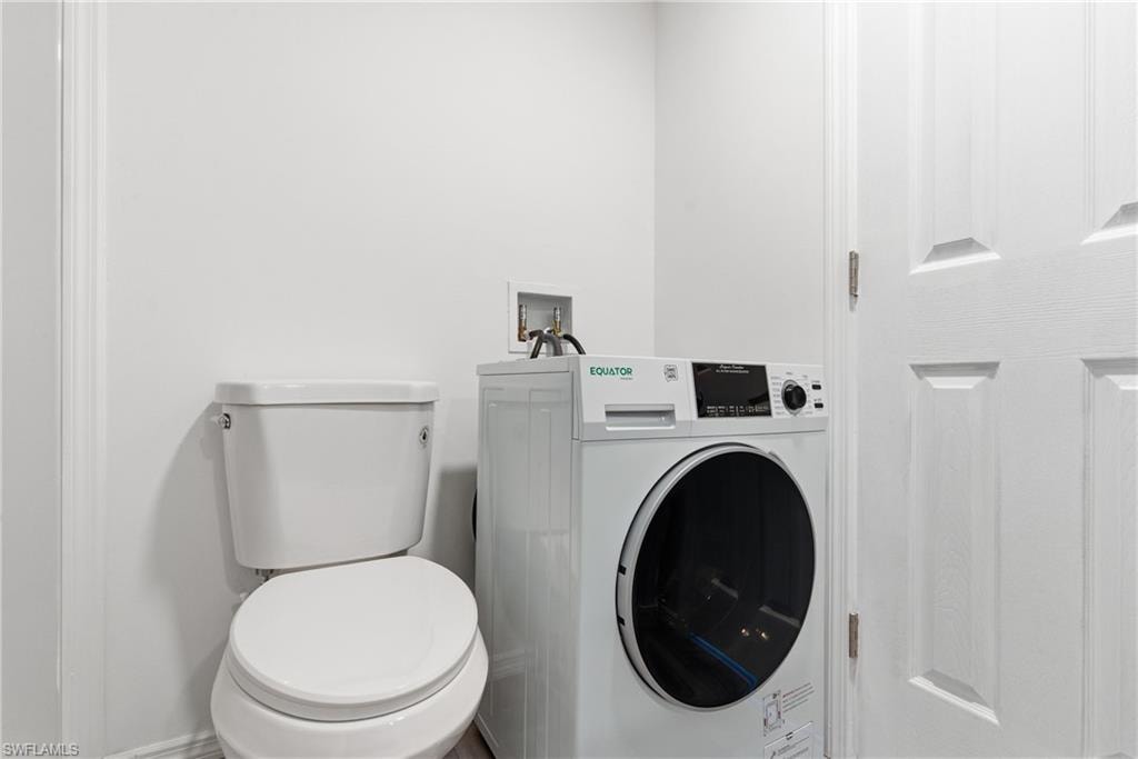 Bathroom with washer / clothes dryer and toilet