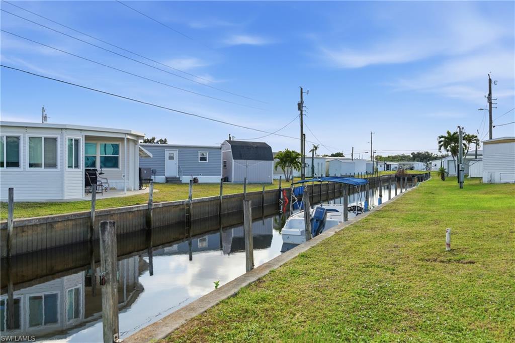 Dock area featuring a water view and a lawn