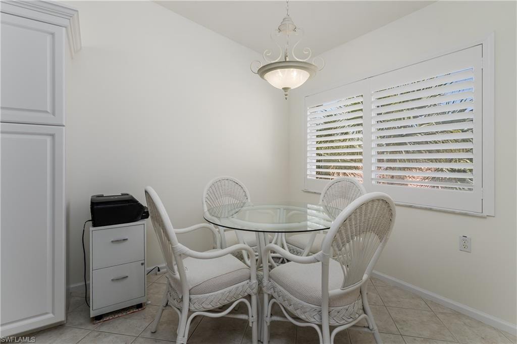 Dining area featuring plantation shutters, overhead chandelier lighting, and a built-in storage cabinet