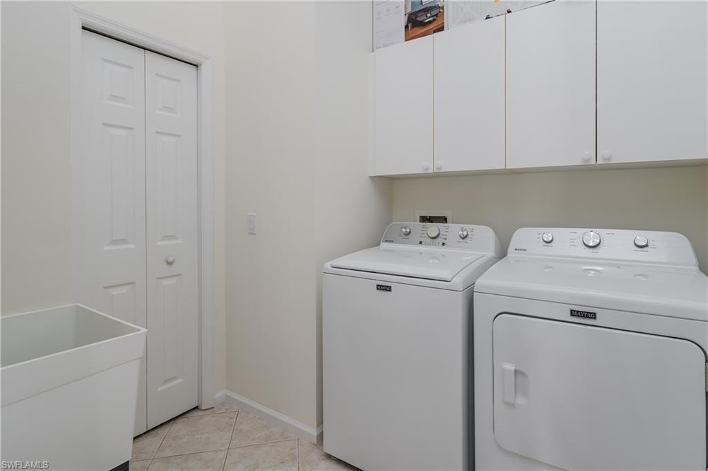 Dedicated laundry space featuring a utility sink, white bi-fold door, and mounted cabinetry for storage