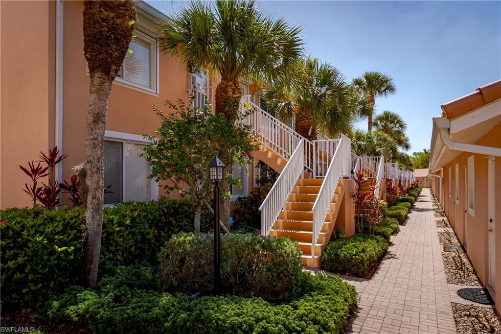The property features multiple levels with exterior staircases, each with white railings