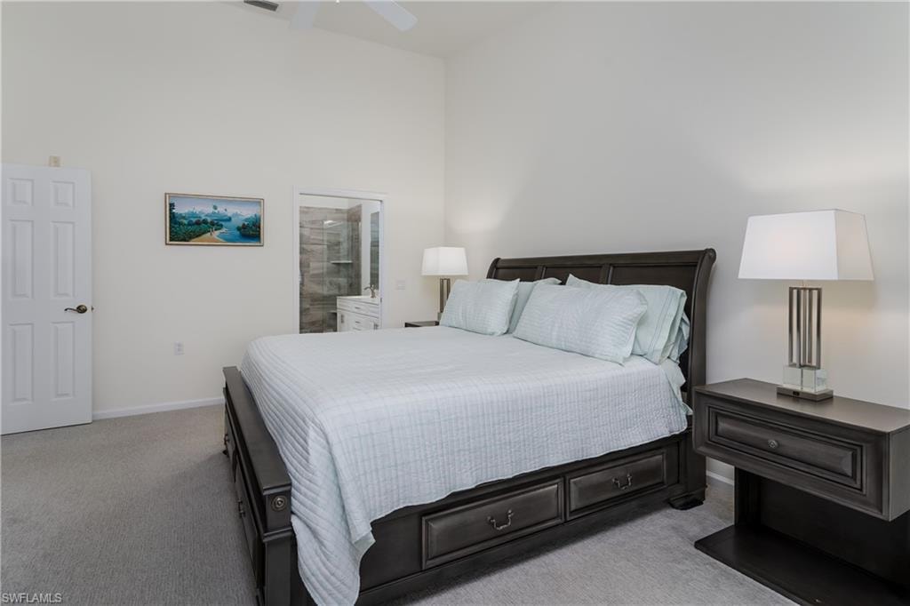 Carpeted room featuring a vaulted ceiling and a ceiling fan