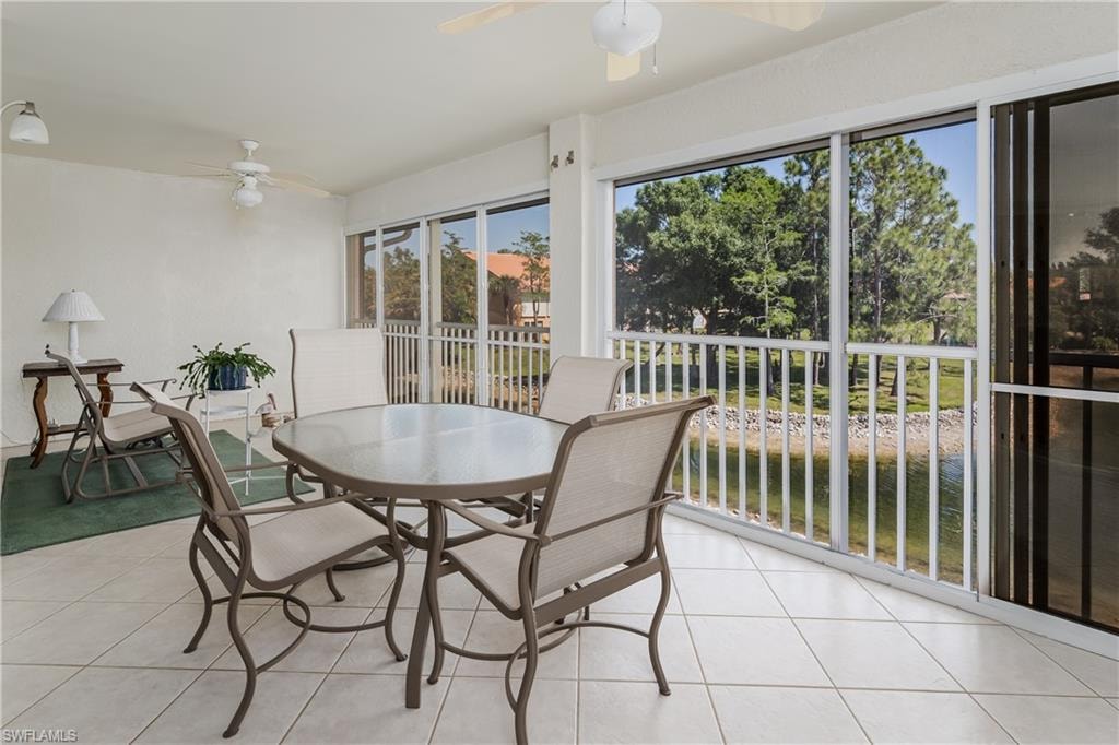 Screened patio featuring tile flooring and ceiling fans