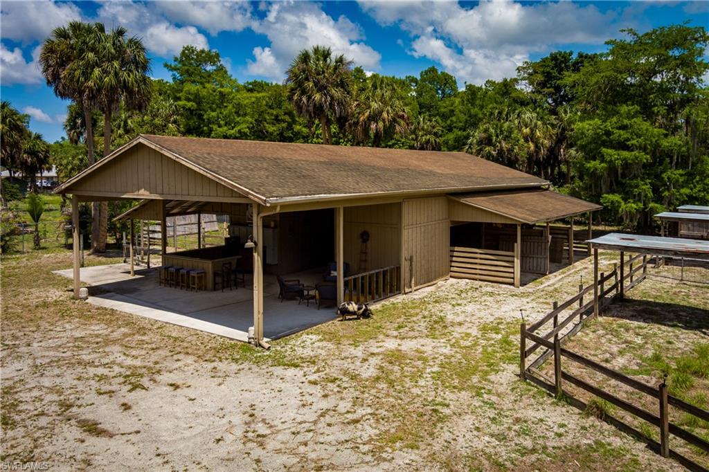 Expansive covered patio featuring a built-in bar, additional outdoor seating, and a dedicated covered stable area