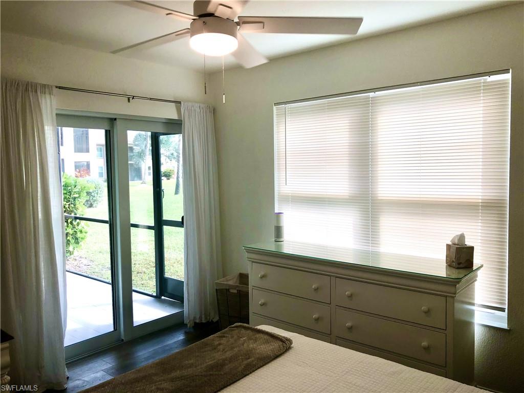 Room featuring wood-finish flooring, a ceiling fan with integrated lighting, and a window with horizontal blinds