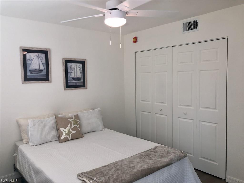 Interior room featuring a white ceiling fan with integrated lighting, a ceiling-mounted air vent, and bi-fold closet doors with panel detailing