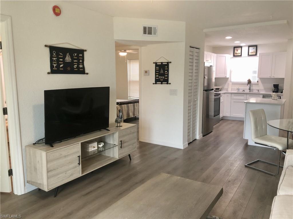 Open-concept living space with wood-finish flooring extending into the kitchen